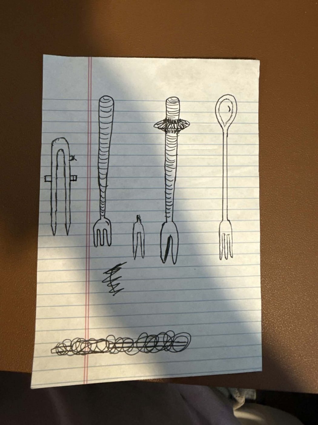 Pen sketch of four pickle fork ideas on lined paper