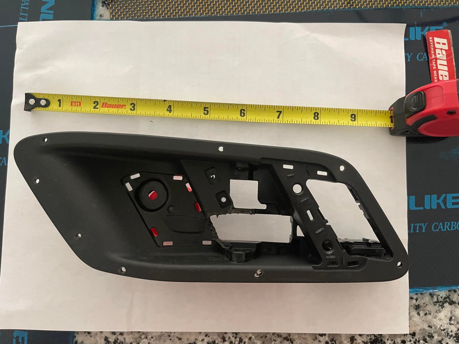 OEM door pull on the bench with a tape for scale